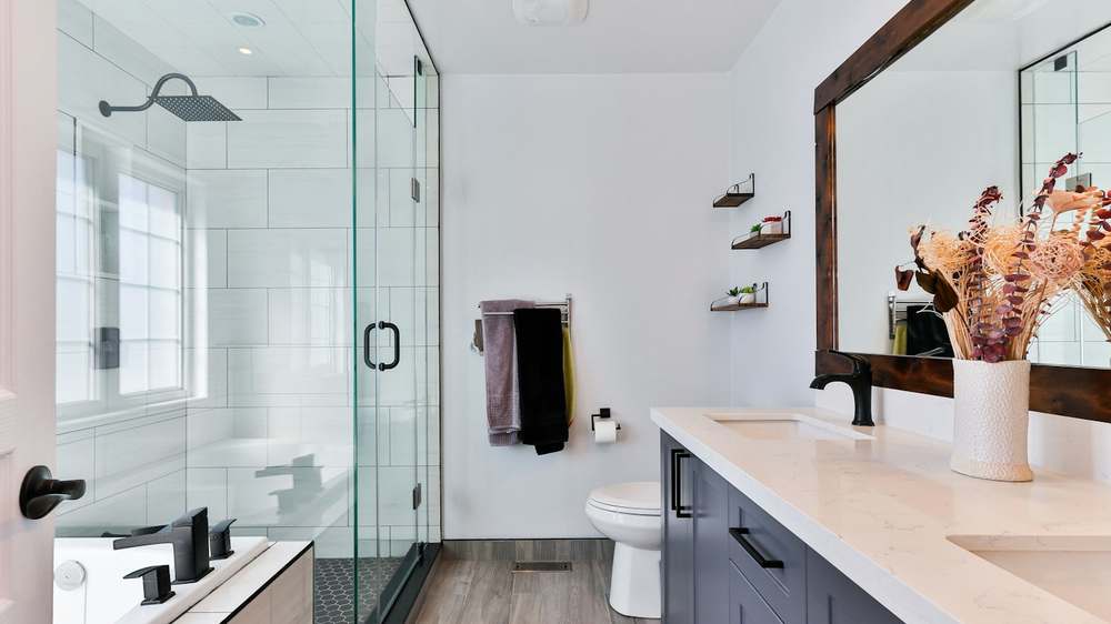 A shower enclosure with a tension-rod caddy holding bottles at arm height