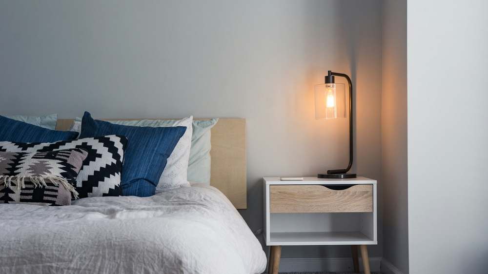 A small bedroom where the rail, door hooks and under-bed storage work together